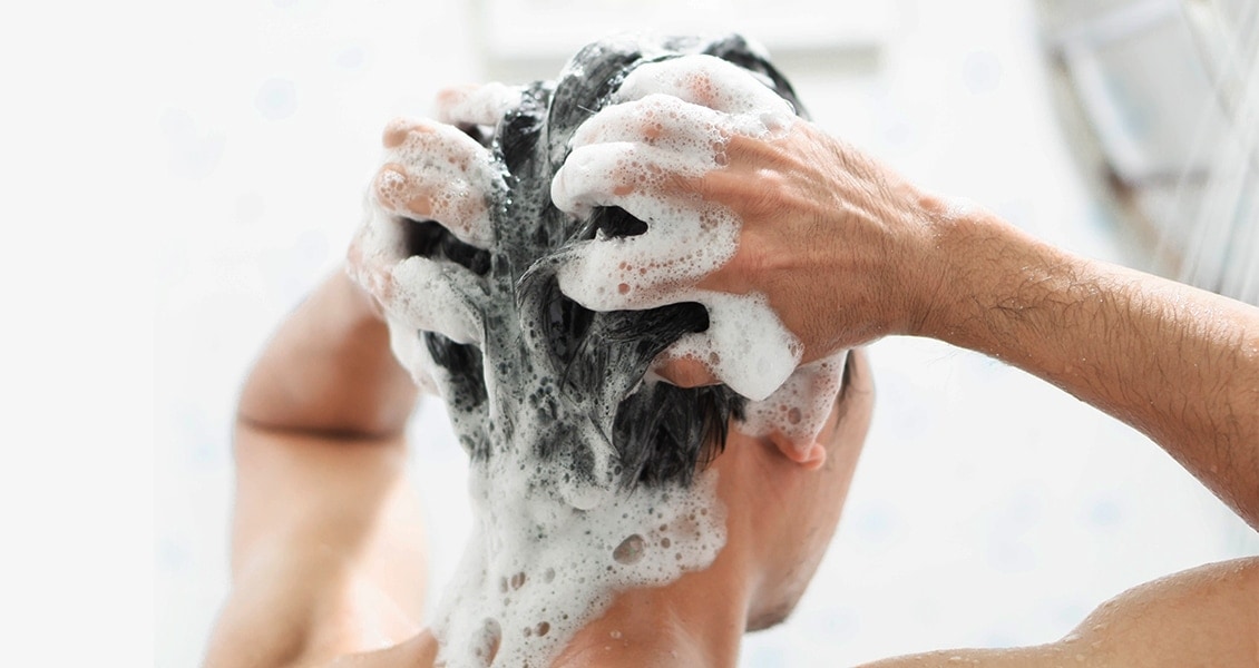 Man washing hair with medicated shampoo.